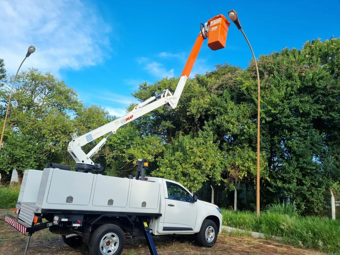 Caminhonete S10 com lança IMAP erguida até uma luminária de rua